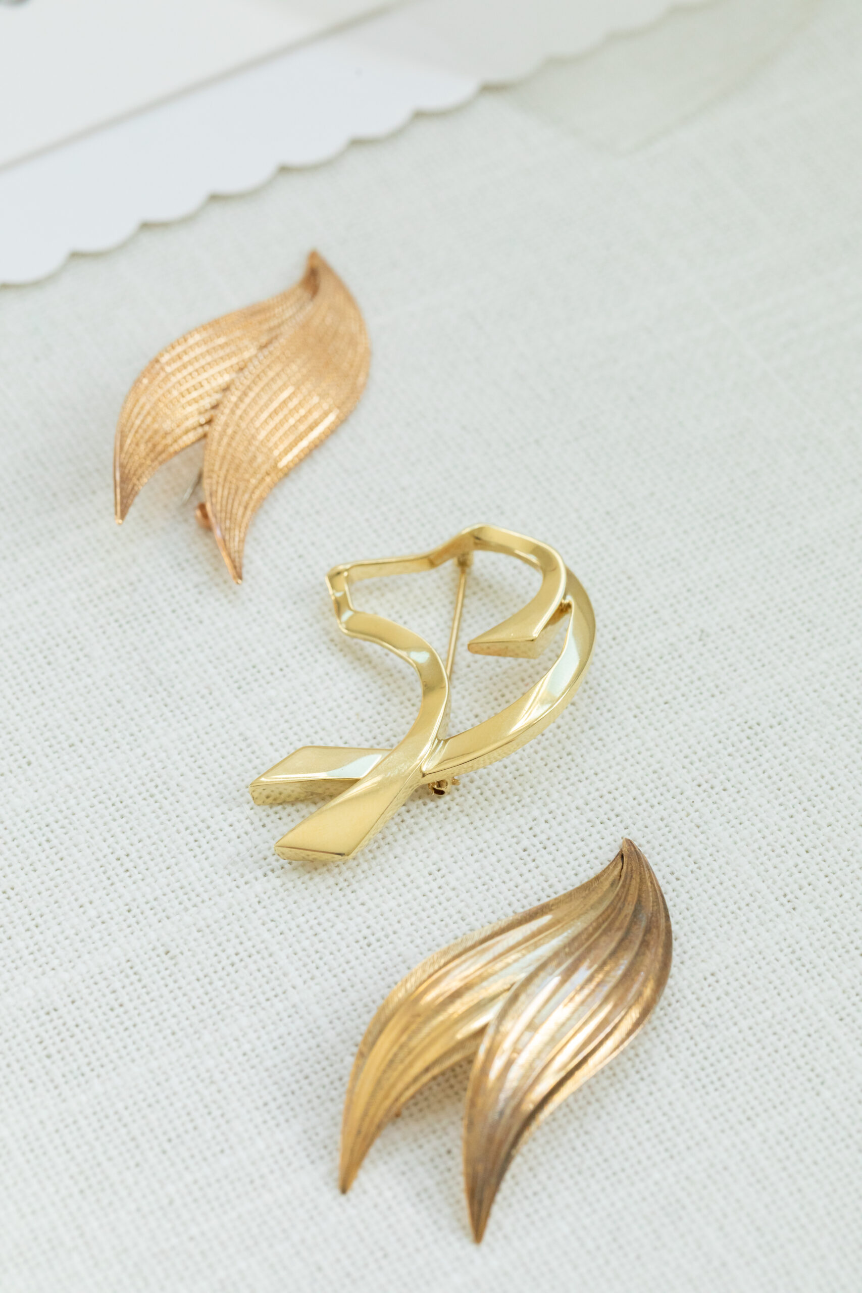Close up of three vintage gold dress pins