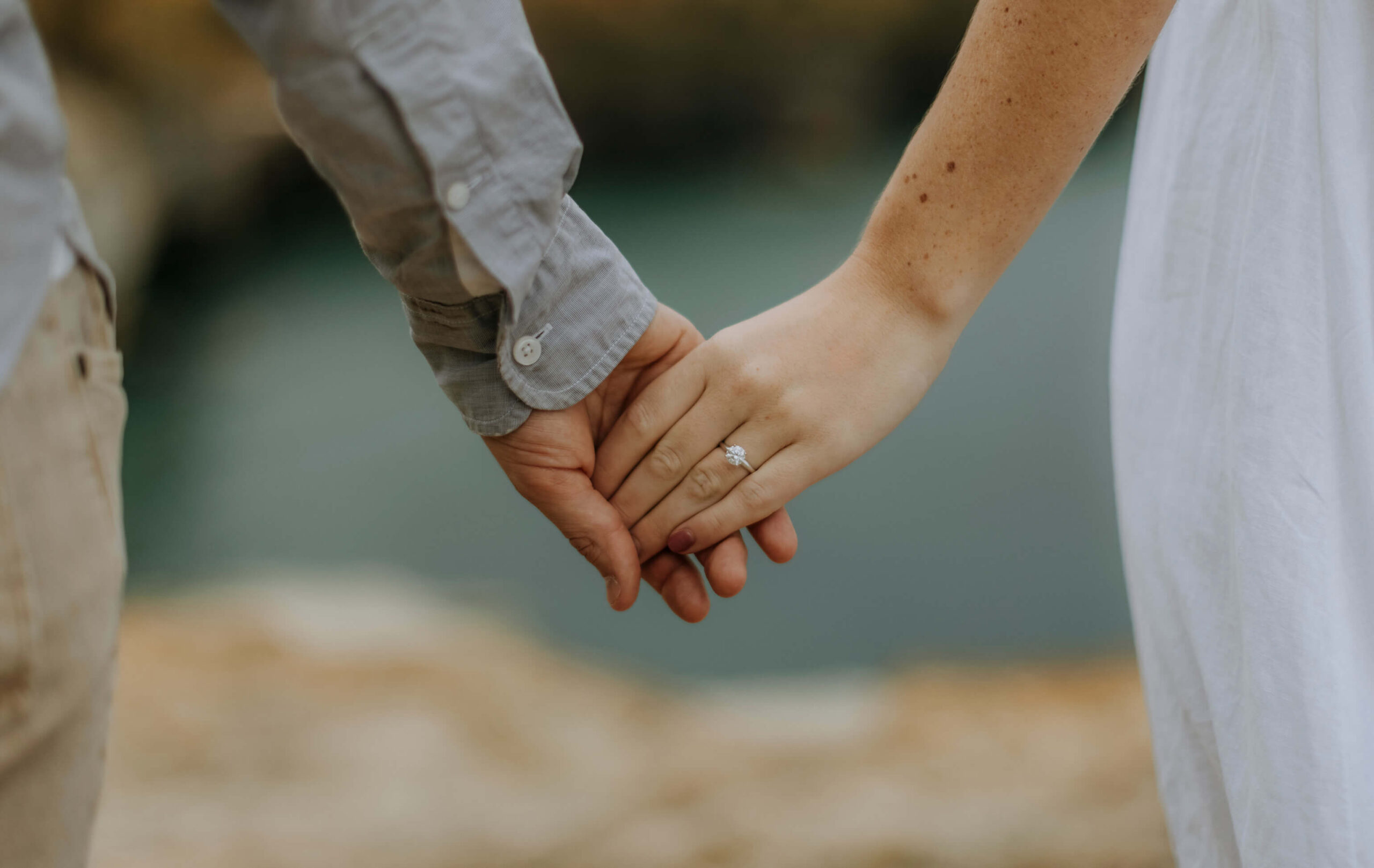 Couple holding hands showing diamond engagement ring from EB Horn in Boston
